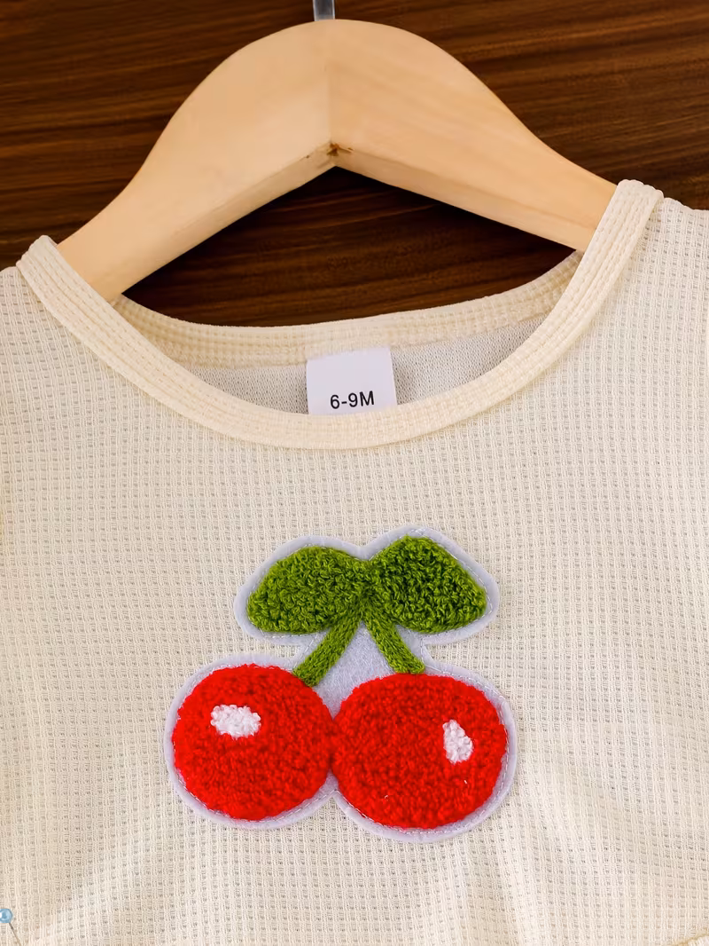 Top sin mangas y pantalón con cerezas bordadas