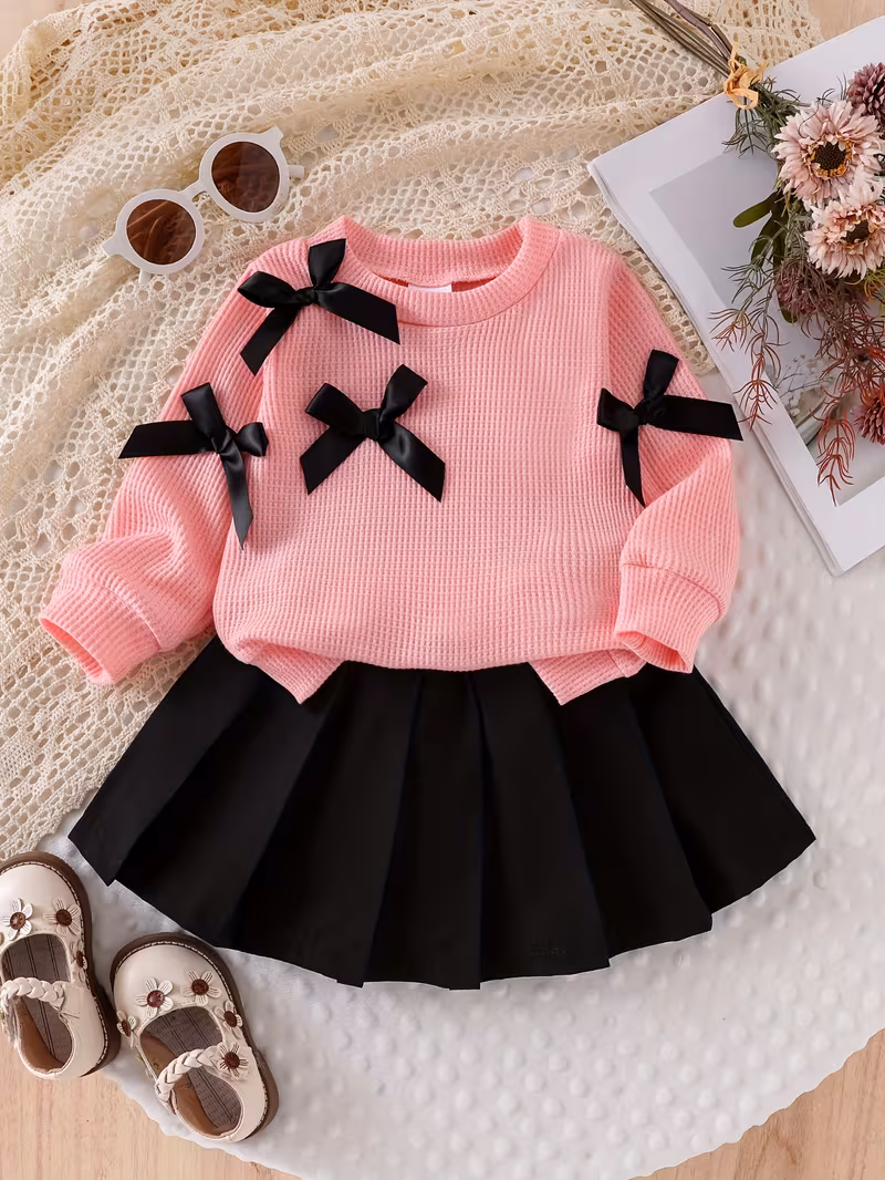 Sudadera fina rosada y falda plisada negra