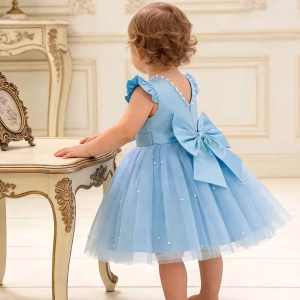 Vestido celeste con lazo en la espalda y adornos de perlas en tul