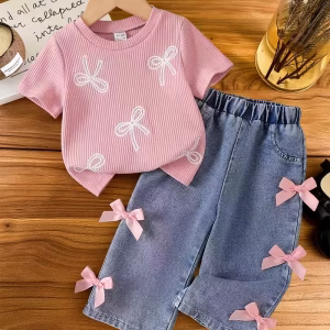 Camiseta rosado claro con diseño de lazo y pantalón de mezclilla decorado con lazo